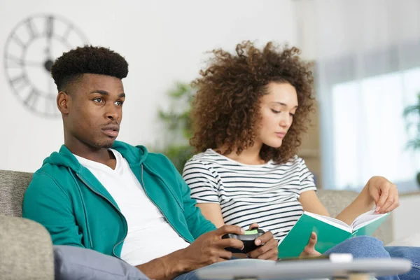 Mulher Lendo Livro Enquanto Homem Joga Jogos Vídeo — Fotografia de Stock