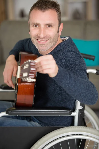 Homem Uma Cadeira Rodas Afinando Sua Guitarra — Fotografia de Stock