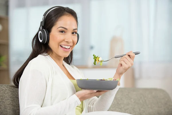 Lycklig Kvinna Med Hörlurar Äter Sallad — Stockfoto