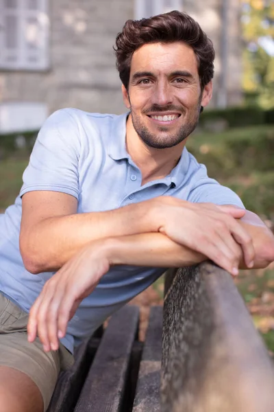 Bonito Jovem Sentado Banco Sorrindo — Fotografia de Stock