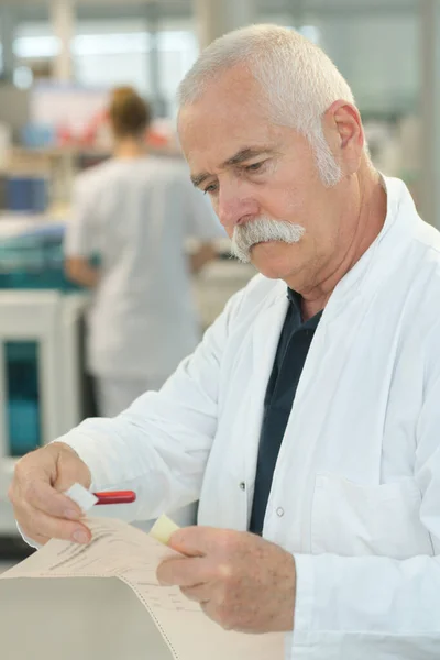 Médico Sênior Positivo Verificando Papel — Fotografia de Stock