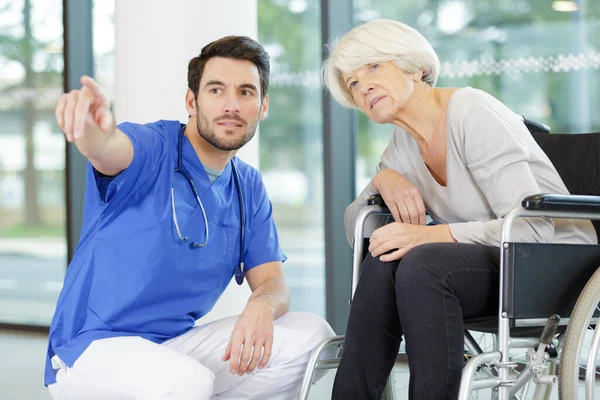 Handsome Male Doctor Helping Out Senior Woman Patient — Stock Photo, Image