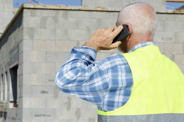 Senior Bouwer Aan Telefoon Buiten Bouw — Stockfoto