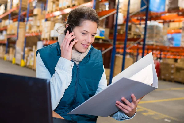 woman warehouse worker or supervisor with smartphone