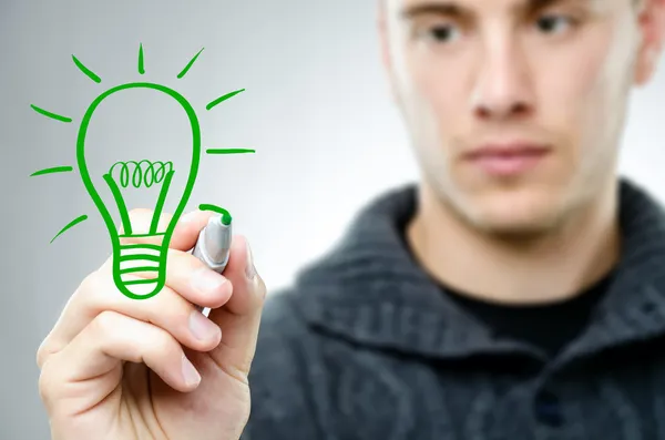 Man draws a green bulb — Stock Photo, Image