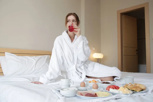 여자가 침대에서 식사를 즐긴다 가정이나 방에서의 목가적 — 스톡 사진