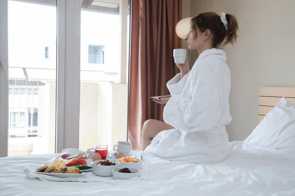 Genç Bir Kadın Yatakta Kahvaltı Yapıyor Evde Otel Odasında Sakin — Stok fotoğraf