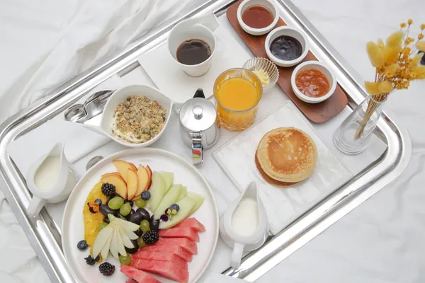 在豪华度假胜地的床上享用早餐盘 在床上早餐 在盘子里放水果 咖啡和果汁 — 图库照片