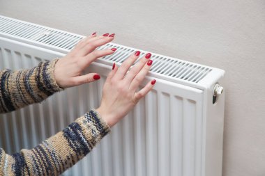 Isıtma radyatör üzerinde kadın ısınma elleri