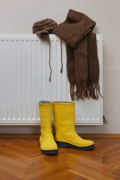 Photo Woolly Hat Scarf Yellow Wellies Boots Drying Radiator — Stock Photo, Image