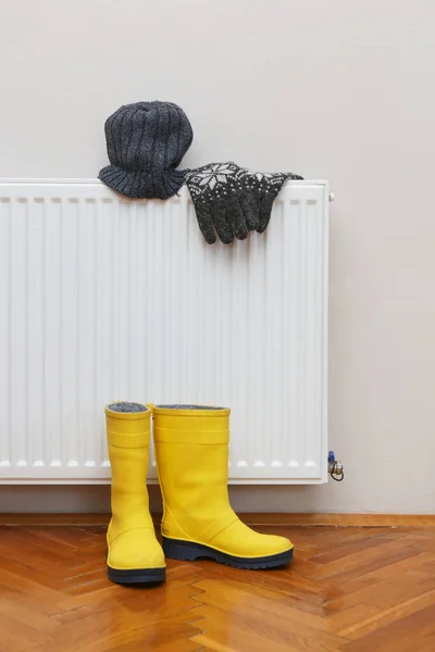 Photo Woolly Hat Gloves Yellow Wellies Boots Drying Radiator — Stock Photo, Image