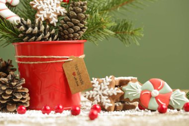 Şenlikli doğal, sıfır atık, plastiksiz, Noel süsü. Geleneksel ev yapımı bisküviler, köknar dalları, çam kozalakları ve kırmızı böğürtlenlerden yapılmış DIY kış tatili ev dekorasyonu.