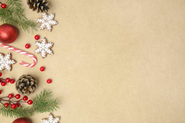 Noel ağacı dalları, kozalaklı kozalaklar, kırmızı böğürtlenler, bayram kurabiyeleri ve süsleri, fotokopi alanı ile üst manzara. Noel, kış tatili, yeni yıl konsepti.