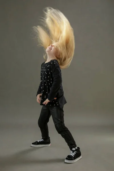 幼児の女の子が踊って長いブロンドの髪で手を振っているスタジオの肖像画 空飛ぶ髪 — ストック写真