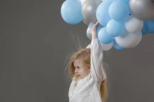 Studio Portret Szczęśliwej Dziewczynki Trzymającej Grupę Białych Niebieskich Balonów Koncepcja — Zdjęcie stockowe