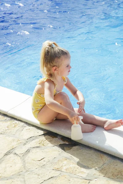 Χαριτωμένο Κοριτσάκι Που Βάζει Αντηλιακή Κρέμα Στα Πόδια Της Αντιηλιακή — Φωτογραφία Αρχείου