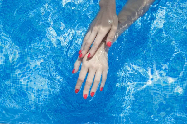 Imagem Das Mãos Mulher Com Esmalte Vermelho Água Azul — Fotografia de Stock