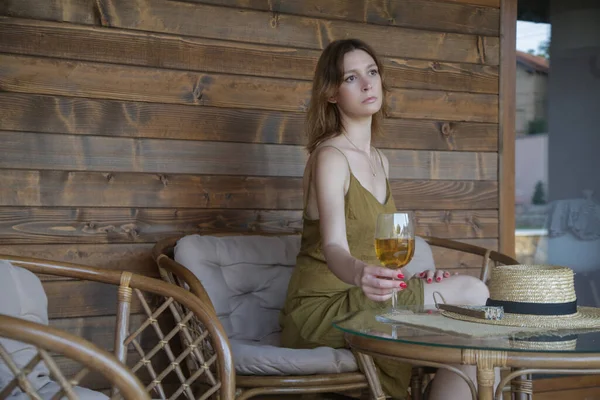 夏の午後には居心地の良い木製のバルコニーでワインを楽しむ若い女性 — ストック写真