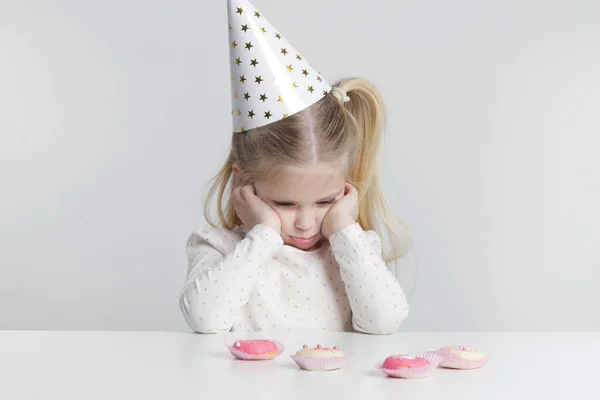 Displeased Little Girl Birthday Hat Donuts Front Her — Fotografia de Stock