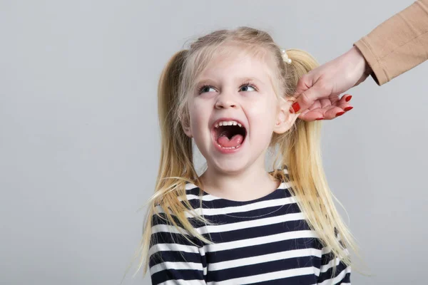Taatsiz Küçük Kız Kulak Çekerek Cezalandırılıyor Stüdyo Çekimi — Stok fotoğraf