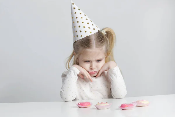 Displeased Little Girl Birthday Hat Donuts Front Her — Fotografia de Stock