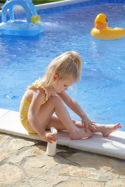 Χαριτωμένο Κοριτσάκι Που Βάζει Αντηλιακή Κρέμα Στα Πόδια Της Αντιηλιακή — Φωτογραφία Αρχείου