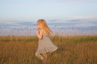 Çayır üzerinde mutlu bir kızın samimi portresi.