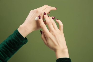 Kadın ellerine koruyucu krem sürüyor. Soğuk mevsim cilt koruması sağlar. Cilt bakımı için organik kozmetik. Güzellik konsepti.