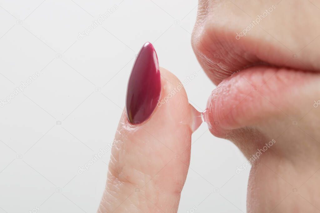 Close up of woman applying lip balm or lip mask.