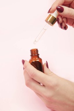 Eller pipeti ve damlatan cam şişeyi yağlı tutsun. Doğal kozmetik, temel yağ, aromaterapi konsepti, cilt bakımı konsepti.