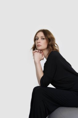 Siyah pamuklu günlük kıyafet, kısa kollu gömlek ve basit pantolon giymiş bir kadının stüdyo fotoğrafı.