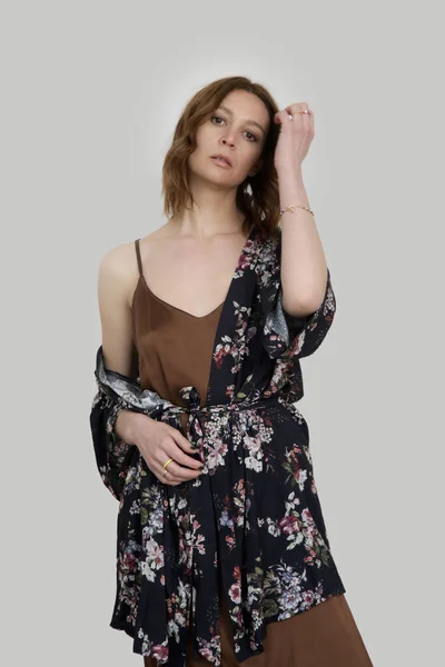 女性で茶色のシルクサテンCamisoleドレスと暗い花のローブ スタジオショット — ストック写真