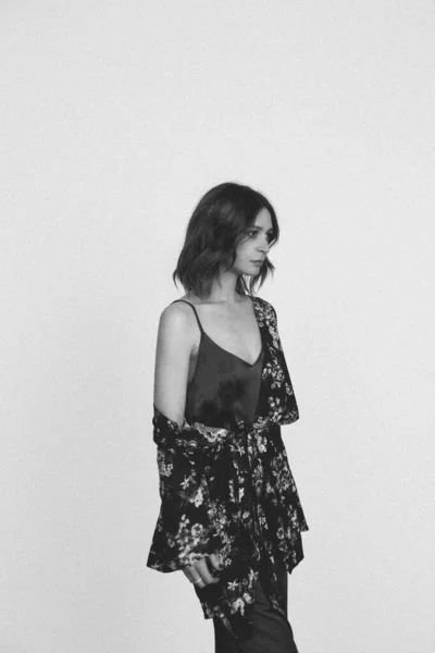黒と白の写真の女性でシルクサテンキャミソールドレスと黒の花のローブ スタジオショット — ストック写真