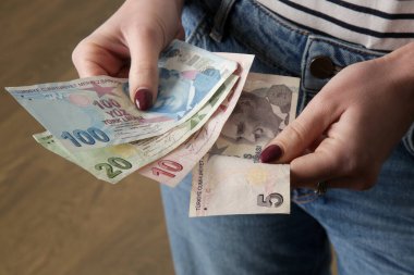 Elinde Türk lirası banknotları tutan kadın.