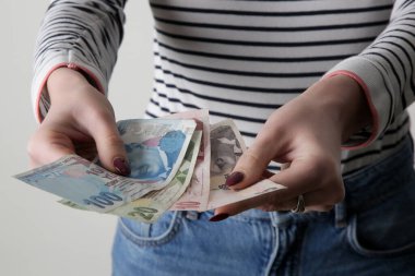Elinde Türk lirası banknotları tutan kadın.