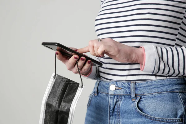 Quitando Máscara Del Concepto Mujer Usando Teléfono Celular Sosteniendo Máscara —  Fotos de Stock