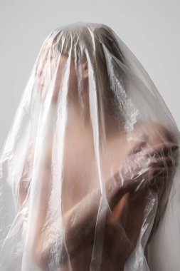 Plastik çarşafa sarılmış bir kadın. Stüdyo çekimi. Kadın ve ruh sağlığı konsepti.