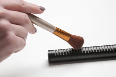 Asmr sesleri yapmak için mikrofonda fırça kullanan kadın