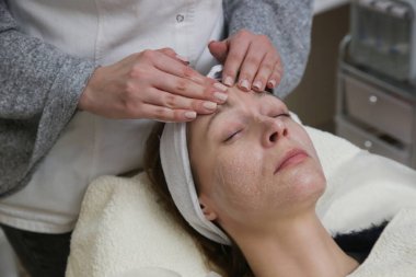 Dermatolog tedavi için kadın derisi hazırlıyor. Temizlik, kabuk soyma ve deri yüzme işlemi.