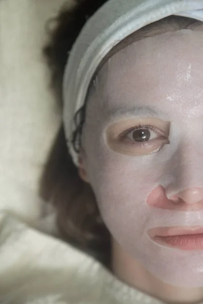 美容室でリラックスした顔のシートマスクの女性 スキンケアコンセプト — ストック写真