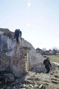 Askerler harabe köyde otomatik silahlarla bir hedefe ateş ediyorlar..