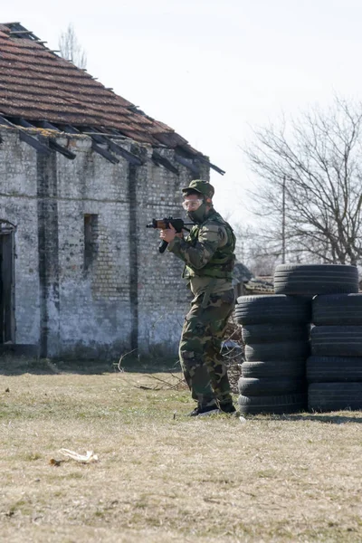 荒廃した村で自動兵器屋外で標的を撃つ兵士 — ストック写真