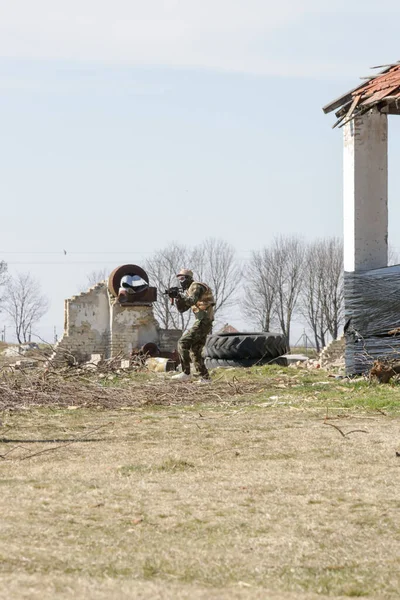 荒廃した村で自動兵器屋外で標的を撃つ兵士 — ストック写真