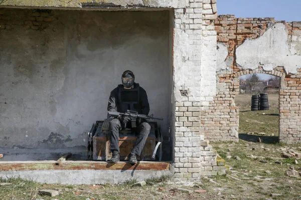 荒廃した村で自動兵器屋外で標的を撃つ兵士 — ストック写真