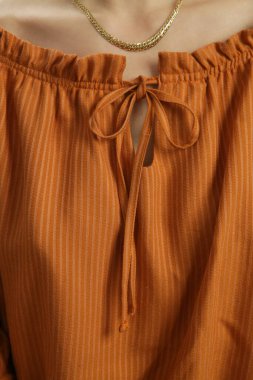 Çizgili turuncu bluzun yakın plan görüntüsü.