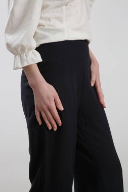 Sıradan siyah beyaz keten elbise giyen bir kadın model. Stüdyo çekimi.