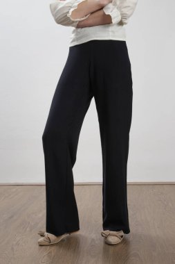 Sıradan siyah beyaz keten elbise giyen bir kadın model. Stüdyo çekimi.