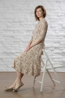 Çiçekli yaz elbisesi giymiş bir kadının stüdyo fotoğrafı..