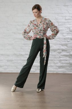 Keten elbise giyen kadın model, çiçekli bluz ve yeşil pantolon. Stüdyo çekimi.