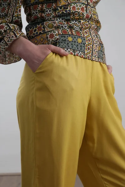 リネンの衣装 カラフルなブラウスと黄色のズボンを身に着けている女性モデル スタジオショット — ストック写真